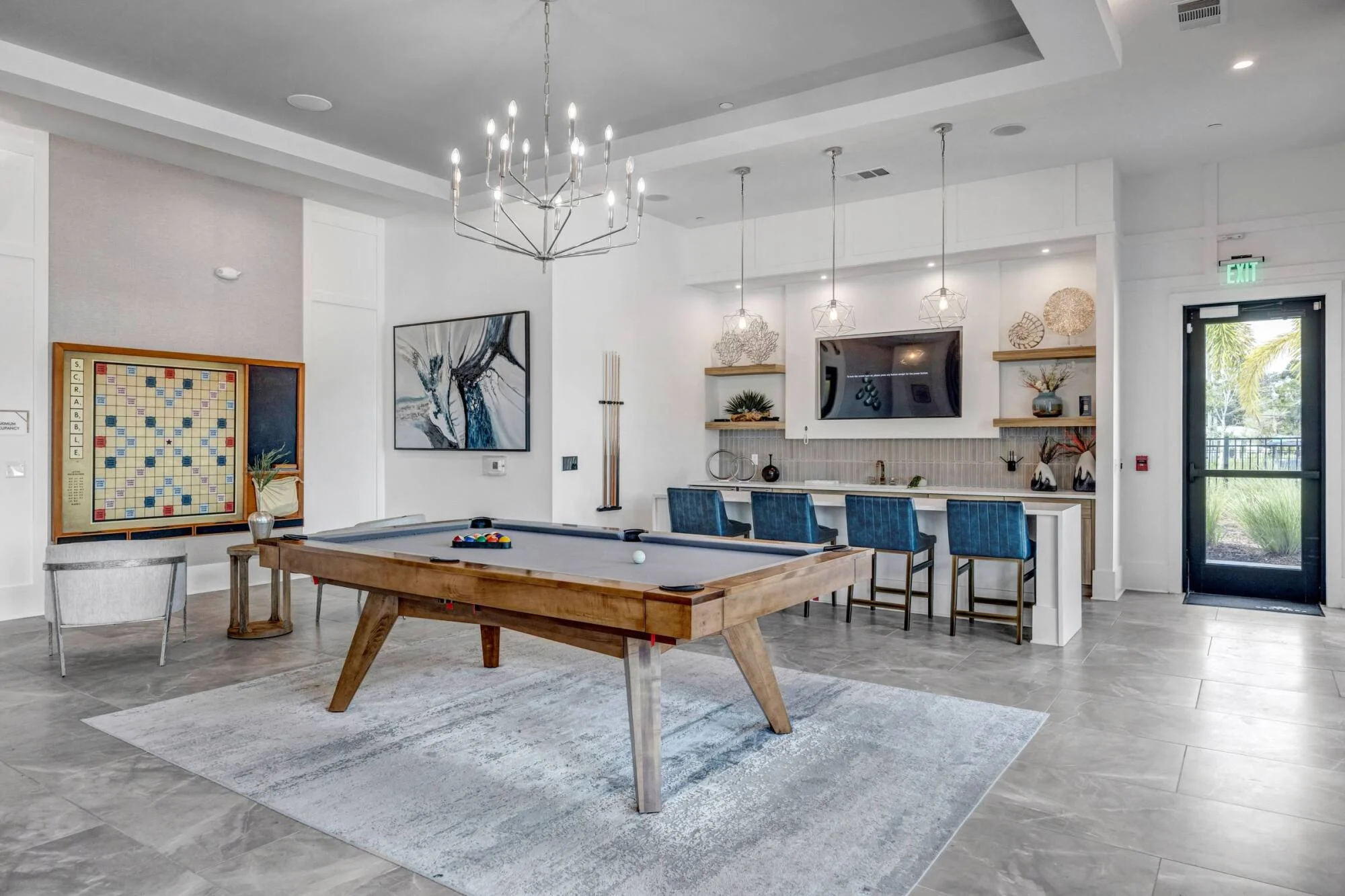 Clubhouse game room at Avasa Hammock Landing in West Melbourne, FL with a pool table, bar seating, and a mounted TV.